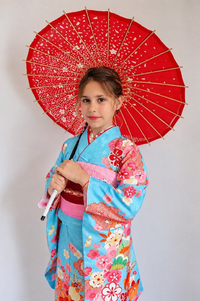 水色の着物に赤い和傘を持つ女の子