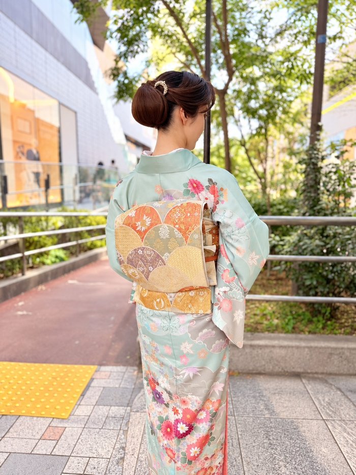 水色の訪問着に袋帯を合わせた女性の後ろ姿
