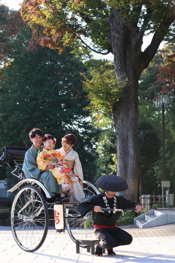 着物姿の家族が人力車に乗り、車夫と記念撮影